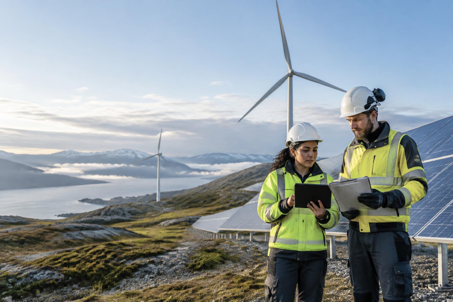 Renewable-energy professionals reviewing work near solar panels